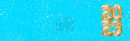 Foto de Helio número globo de oro del año 2023. Guirnalda festiva brillante con bokeh sobre fondo azul. Feliz año nuevo banner - Imagen libre de derechos