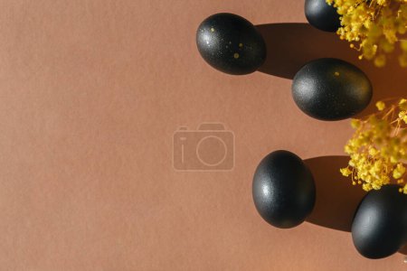 Photo for Eggs painted black on white background. Minimal Easter concept with copy space for text. Golden luxury backdrop - Royalty Free Image