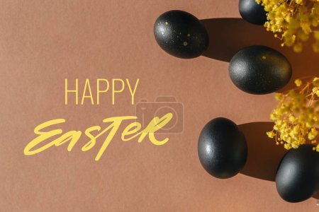 Foto de Eggs painted black on white background. Minimal Easter concept with copy space for text. Happy Easter lettering - Imagen libre de derechos