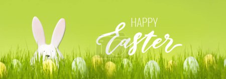 Photo for Bunch of eggs with dots on green background. Cute decor on a meadow. Greeting card with wishes. Easter egg hunt poster. Bunny rabbit ears sticking out of the grass - Royalty Free Image