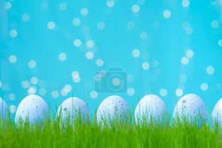 Foto de Decorated Easter lilac eggs in grass. Concept of Easter egg hunt. Background, web banner or flyer with copy space for text - Imagen libre de derechos