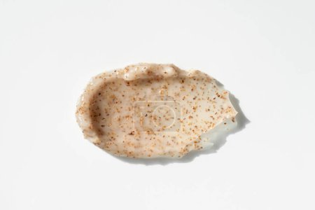 Téléchargez les photos : Body scrub texture with apricot kernel on white background. Cosmetic smear. Appearance of the texture of the swatch. Natural skincare products. Beauty concept for face and body care. - en image libre de droit