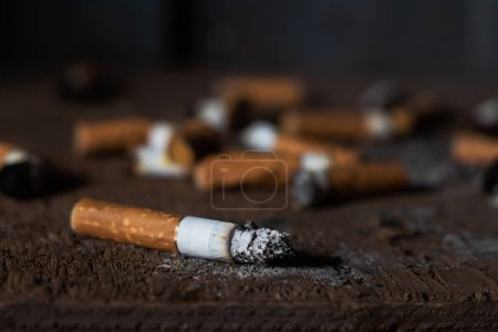 Foto de Colillas de cigarrillos sobre un fondo negro. Colillas de cigarrillo. Cigarrillo. - Imagen libre de derechos