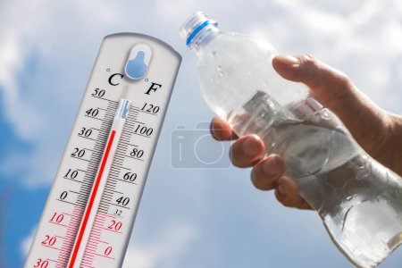 Photo for Hot temperature,Thermometer and water bottle on sky with sun shining in summer show higher Weather, concept global warming. - Royalty Free Image