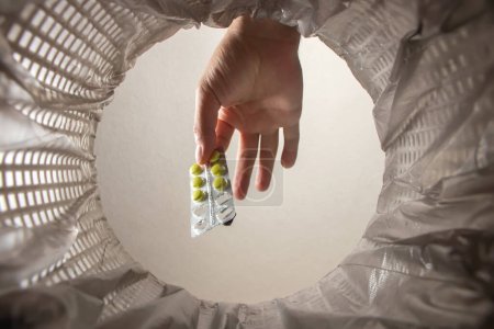 Foto de Tira las pastillas en el cubo, las pastillas en la mano dentro de la vista. - Imagen libre de derechos
