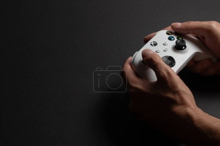 Photo for 30 August 2023, Dnipro, Ukraine: Xbox Series S controller on man hand on dark background - Royalty Free Image