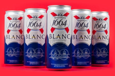 Photo for Dnipro, Ukraine, 13 oct, 2023: Aluminium cans of beer brands Kronenbourg 1664 Blanc owned by the Carlsberg Group on red background. - Royalty Free Image