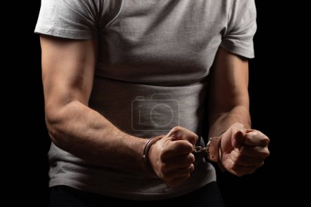 The arrested criminal handcuffed. Hands with handcuffs in the front.