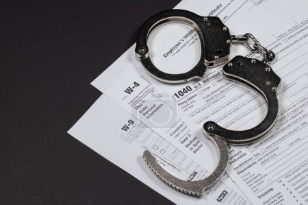 Photo for Income tax return documents and handcuffs. Tax evasion, crime and fraud concept - Royalty Free Image
