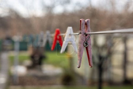 Plastic Clothespin on a hanger. Colored old cloth clips on a cloth rope