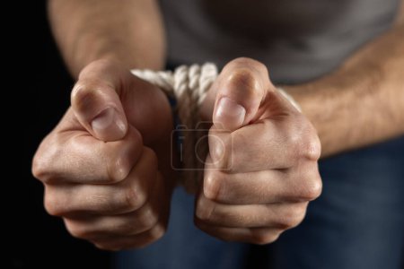 Man's hands tied with a rope Close up.