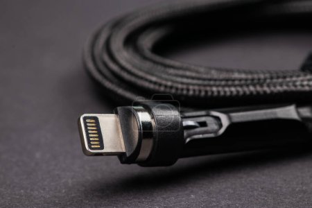 Téléchargez les photos : USB câble de données blanc éclair sur fond sombre. - en image libre de droit