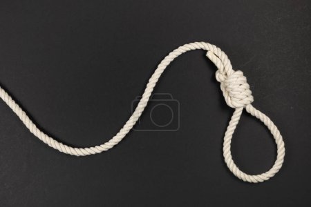Rope noose for hangman, suicide made of natural fiber rope on dark background. Hemp rope noose for homicide or commit suicide concept. Hang rope knot for gallows and Hang mans real