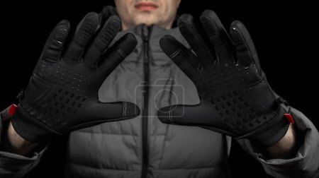 Hands in black thermal gloves in winter.