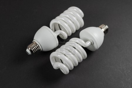 Téléchargez les photos : Ampoule fluorescente à économie d'énergie CFL sur fond sombre. - en image libre de droit