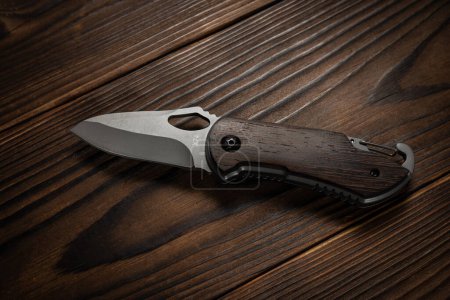 Tactical knife on a wooden background.