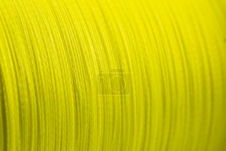 Yellow fishing braided line close up. Spool of green cord isolated. Spool of braided fishing line.
