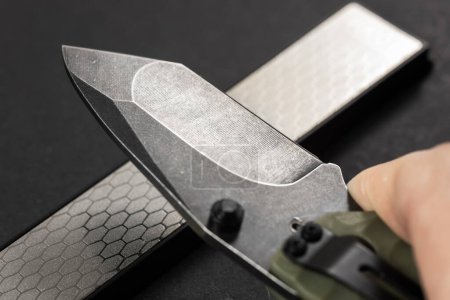sharpening the knife with whetstone, close up.