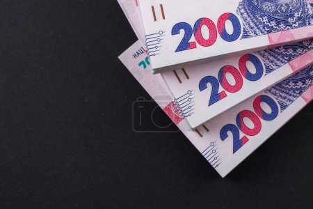 a pack of hryvnias on the table. Financial concept. Ukrainian money. 200 hryvnia on dark background