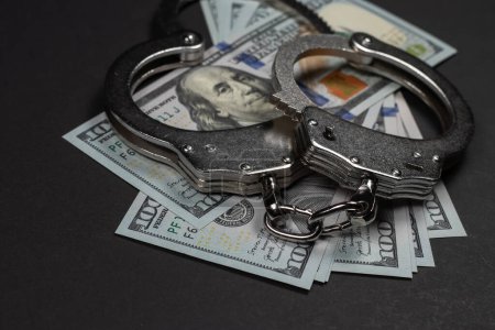 The handcuffs are on hundred-dollar bills. Power and bribery. Criminal ransom. Criminal earnings. Business concept. The concept of wealth.