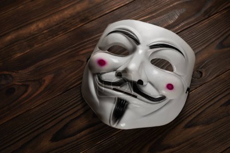Dnipro. Ukraine 30. Januar 2024: Vendetta-Maske auf Holzgrund. Diese Maske ist ein bekanntes Symbol für die Online-Hackergruppe Anonymous.