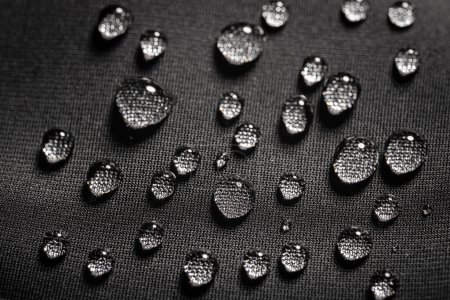 Close-up view on water drops on waterproof impregnated fabric in rain.