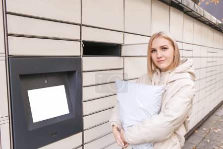 Photo for Blonde woman hold the parcel near self-service mail terminal. Parcel delivery machine. - Royalty Free Image