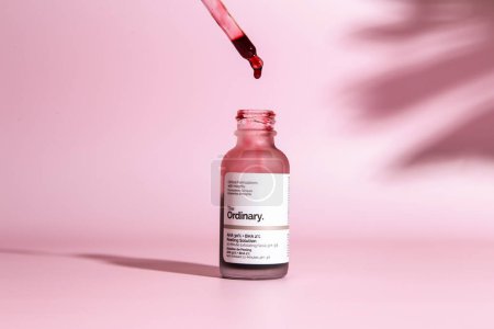 Photo for Warszaw, Poland - May, 2023: The Ordinary skincare brand by Deciem. Bottles with red peeling and solutions. Closeup of The Ordinary Peeling on pink background - Royalty Free Image