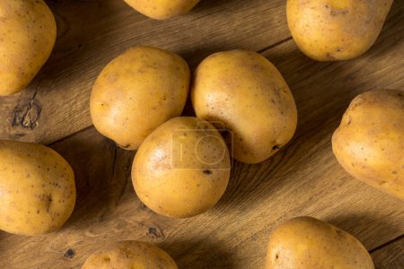 Foto de Patatas amarillas crudas caseras en un racimo - Imagen libre de derechos