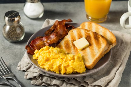Foto de Desayuno de huevos revueltos americanos caseros con tocino y tostadas - Imagen libre de derechos