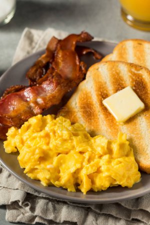 Photo for Homemade American Scrambled Egg Breakfast with Bacon and Toast - Royalty Free Image