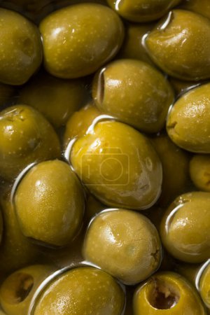 Foto de Raw Green Organic Marinated Olives in Oil - Imagen libre de derechos