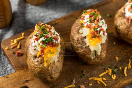 Foto de Homemade Loaded Baked Potatoes with Bacon Cheddar and Sour Cream - Imagen libre de derechos