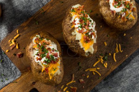 Photo for Homemade Loaded Baked Potatoes with Bacon Cheddar and Sour Cream - Royalty Free Image