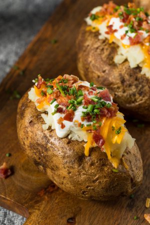 Photo for Homemade Loaded Baked Potatoes with Bacon Cheddar and Sour Cream - Royalty Free Image