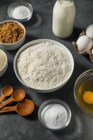Photo for Organic Raw Baking Ingredients with Flour Sugar Milk and Eggs - Royalty Free Image
