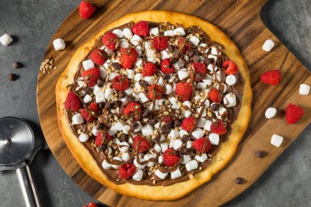 Foto de Pastelería casera de pizza de avellana con chocolate dulce con malvaviscos y frambuesas - Imagen libre de derechos