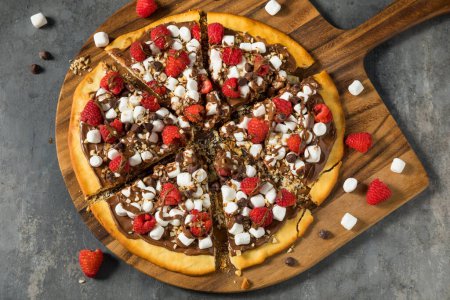Foto de Pastelería casera de pizza de avellana con chocolate dulce con malvaviscos y frambuesas - Imagen libre de derechos
