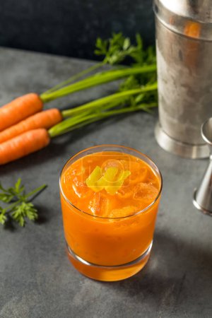 Photo for Cold Boozy Raw Carrot Bourbon Cocktail with Lemon Juice - Royalty Free Image