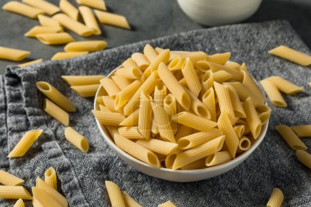 Photo for Dry Organic Penne Pasta in a Bowl - Royalty Free Image