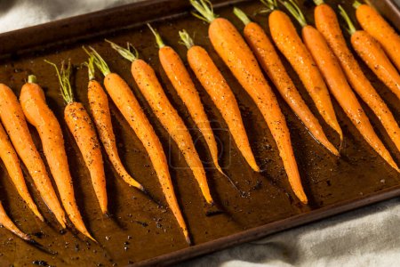 Téléchargez les photos : Carottes rôties entières biologiques à l'orange crue avec sel et poivre - en image libre de droit