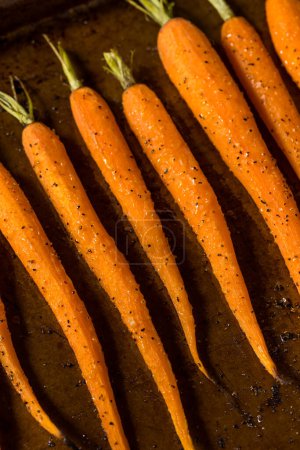 Photo for Raw Orange Organic Whole Roasted Carrots with Salt and Pepper - Royalty Free Image