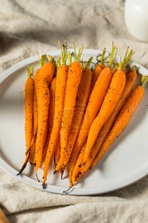Photo for Raw Orange Organic Whole Roasted Carrots with Salt and Pepper - Royalty Free Image