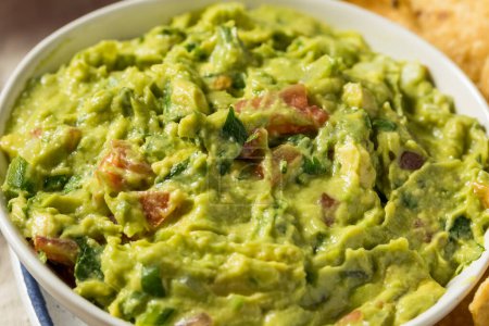Photo for Homemade Avocado Guacamole and Tortilla Chips with Tomato - Royalty Free Image