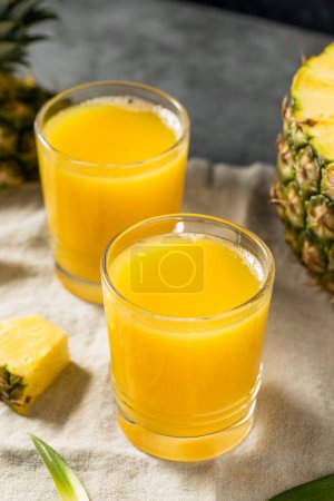 Foto de Zumo de piña amarillo refrescante en frío listo para beber - Imagen libre de derechos