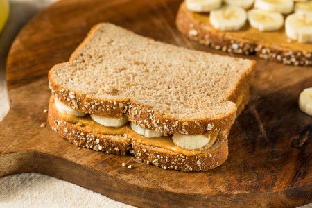 Téléchargez les photos : Sandwich à la banane au beurre d'arachide sain fait maison sur pain de blé - en image libre de droit
