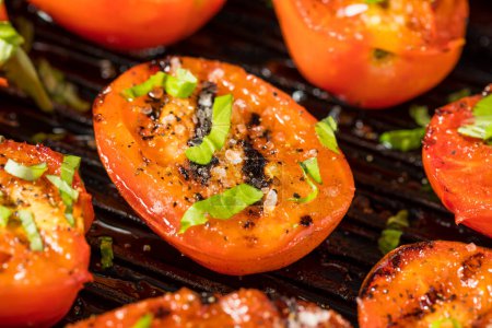Foto de Apitizador de tomate rojo asado ecológico con sal y albahaca - Imagen libre de derechos