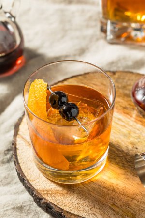 Photo for Boozy Maple Syrup Old Fashioned Cocktail with Bourbon and Cherries - Royalty Free Image