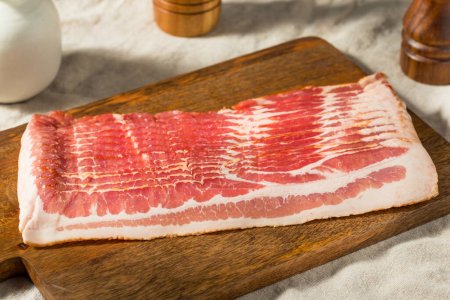 Téléchargez les photos : Bacon cru biologique rouge coupé en tranches - en image libre de droit