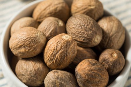 Photo for Organic Dry Whole Nutmeg in a Bowl - Royalty Free Image